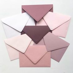 many different colored envelopes stacked on top of each other with one being folded up