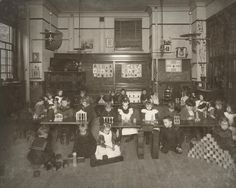 an old black and white photo of children sitting at desks