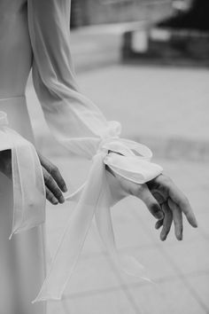 black and white photograph of hands tied to the back of a woman's dress