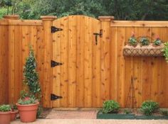 a wooden fence with potted plants on it