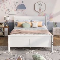 a white bed sitting on top of a wooden floor next to a dresser and lamp