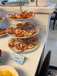 three tiered trays filled with different types of pizza and other foods on top of a counter