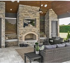 an outdoor living area with couches and fireplace