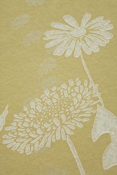 a close up of a yellow paper with white flowers on it