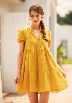 Brighten your wardrobe with this radiantly mustard yellow babydoll dress, a charming piece from our ModCloth namesake label. The playful button detailing on the chest complements its flowy form and mini length, while puff sleeves add a whimsical touch. Perfect for sundrenched picnics or casual brunches with friends, this dress pairs wonderfully with sandals or sneakers. Its delightful hue and breezy fabric invite you to frolic in the sunshine, ready to make joyful memories in sublime comfort and Flowy Yellow Bohemian Mini Dress, Yellow Babydoll Dress, Yellow Babydoll Top, Casual Mini Dress With Smocked Bodice And V-neck, Casual V-neck Smocked Bodice Mini Dress, Fabric Invitation, Halloween Shoes, Gold Nugget, Plus Size Coats