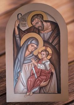 an image of jesus and mary on a wooden table with wood grains in the background