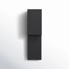 a black object is hanging on the wall in front of it's white background