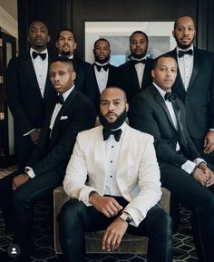 a group of men in tuxedos posing for a photo