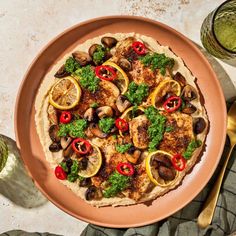 an overhead view of a pizza on a plate with lemons, mushrooms and broccoli