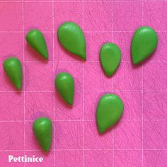 several green pieces of plastic on a pink background with the words pettince written below them