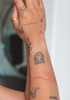 a woman with tattoos on her arm holding a cell phone