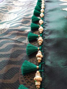 green tasselled fabric with gold beading and beads on the bottom part of it