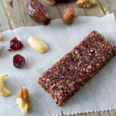 a piece of food sitting on top of a piece of paper next to nuts and cranberries