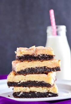 three pieces of cake sitting on top of a white plate next to a bottle of milk