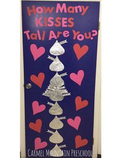 a door decorated with paper hearts and the words how many kisses? tall are you?