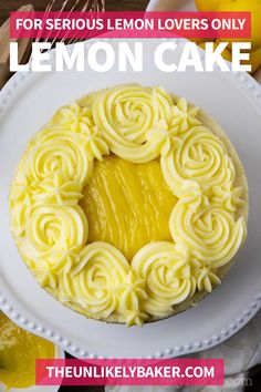 a white plate topped with a cake covered in yellow icing next to lemons