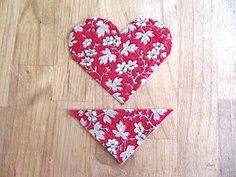 two pieces of fabric are laid out on the floor to make a heart - shaped ornament