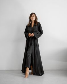 An elegant robe made of Armani silk fabric is presented in a maxi length. The model is styled with long wide sleeves and a belt. The robe emphasizes the figure well and goes well with a nightgown. Available in the following sizes: 42-46 and 48-52 Sizes: This PJ is available in sizes S-M, L-XL Body Measurements: Size  S - M:  Bust measurement - 45-48 cm,   Hips - 51 сm (stretches),  Robe length - 140 cm,  Sleeve length - 53 cm Size  L - XL:  Bust measurement - 50-54 cm,   Hips - 57 сm (stretches),  Robe length - 142 cm,  Sleeve length - 53 cm Colors: Black, White, Gray Materials:  All PJ sets are made of comfortable Armani silk. It's a breathable and allergy-friendly material. Great in terms of thermoregulation.  Fabric content:  Armani silk (50% silk, 45% viscose, 5% elastane) Breathable W Elegant Long Silk Kimono, Elegant Silk Floor-length Robe, Elegant Floor-length Silk Robe, Long Silk Evening Kimono, Elegant Evening Abaya For Fall, Elegant Floor-length Fall Abaya, Chic Long Sleeve Satin Kimono, Formal Long Silk Robe, Elegant Belted Abaya