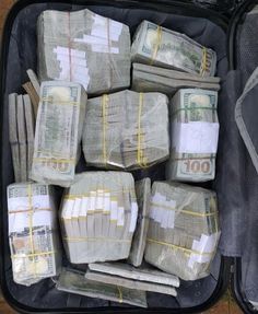 an open suitcase filled with bundles of money