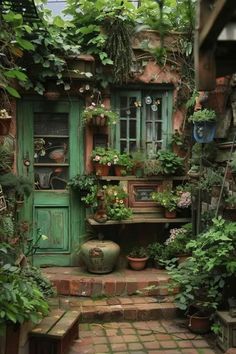 an outdoor garden with potted plants and pots on the steps leading up to a green door