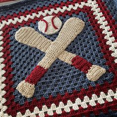 a crocheted blanket with baseballs and bats on it in red white and blue