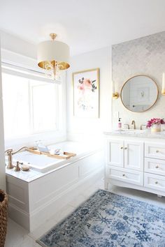 a bathroom with a tub, sink and large mirror in the corner by the window