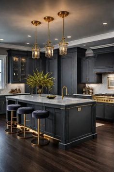 a large kitchen with black cabinets and gold accents on the countertops, along with two stools