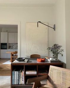 a living room filled with furniture and a painting on the wall above it's bookshelf