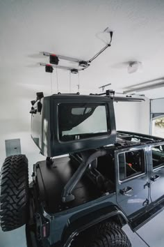 the jeep is parked in the garage with its roof rack on it's flatbed