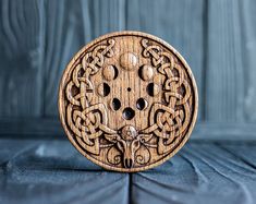 an intricately carved wooden object sitting on top of a blue cloth covered tablecloth