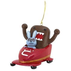 a christmas ornament with a cartoon character in a toy car that is shaped like a dog