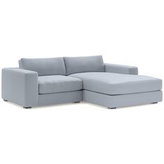 a light blue sectional couch sitting on top of a white floor