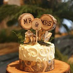 a wedding cake decorated with wooden slices and mr and mrs topper on a tree stump