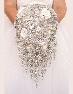 the bride's bouquet is made up of pearls and brooches, which are embellished with jewels