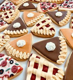 many different types of pies and cookies on a table with white frosting in the middle