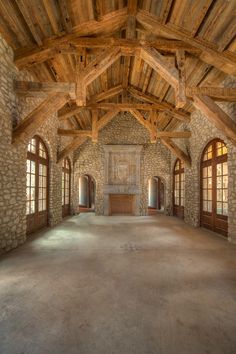 an empty room with stone walls and wooden beams on the ceiling is seen in this image