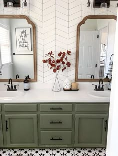 a bathroom with green cabinets and black and white floor tiles on the walls, along with a vase filled with flowers