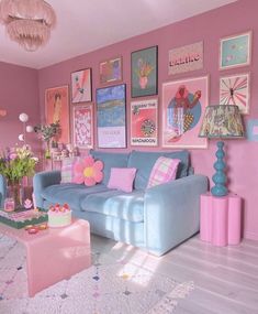 a pink and blue living room with pictures on the wall, couches and tables