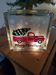 a glass block with a red truck and christmas tree on it