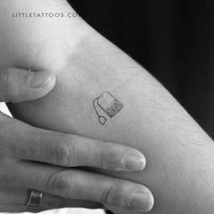 black and white photo of a person's arm with a small tattoo on it