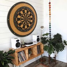 a living room filled with furniture next to a wall mounted dart board on the wall