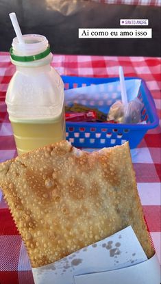 a piece of bread and a drink on a table with a checkered tablecloth