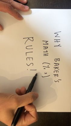 a person writing on a piece of paper with a pen in their left hand and another hand holding a black ballpoint pen