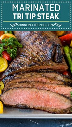 marinated strip steak on a platter with asparagus and tomatoes