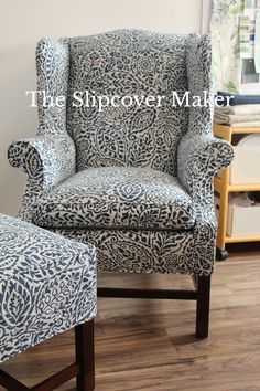 an upholstered chair and footstool in a living room with wood flooring