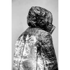 a black and white photo of a person wearing a jacket with the hood pulled back