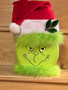 a green christmas hat on top of a wooden shelf