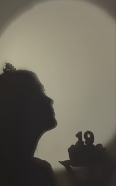 the silhouette of a woman holding a tea pot