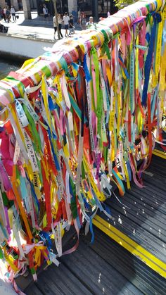 many ribbons are tied together on the back of a bench in front of a building