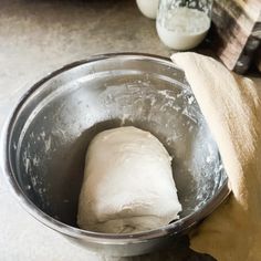 a metal bowl filled with dough on top of a counter